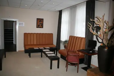 a waiting room with a bench and a table at Zorn Hotel Duinlust in Noordwijk aan Zee