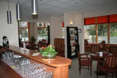 a restaurant with a bar with wine glasses on it at Zorn Hotel Duinlust in Noordwijk aan Zee