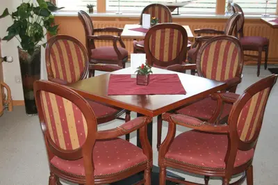 a table and chairs with a red napkin on it at Zorn Hotel Duinlust in Noordwijk aan Zee
