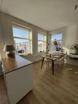 a kitchen and dining room with a table and windows at Authentic sunny Amsterdam Jordaan apartment in Amsterdam