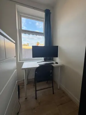 a desk with a computer on it with a window at Authentic sunny Amsterdam Jordaan apartment in Amsterdam