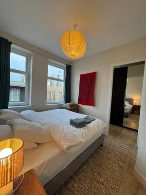 a bedroom with a large bed and a chandelier at Authentic sunny Amsterdam Jordaan apartment in Amsterdam