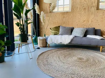 a living room with a couch and a rug at De Wagenloods in Alphen aan den Rijn