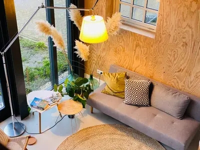 a living room with a couch and a lamp at De Wagenloods in Alphen aan den Rijn