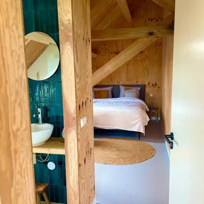 a bedroom with a bed and a sink and a mirror at De Wagenloods in Alphen aan den Rijn