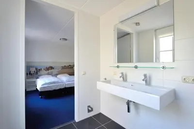 a bathroom with a sink and a mirror at Buitenplaats Witte Raaf aan Zee in Noordwijk