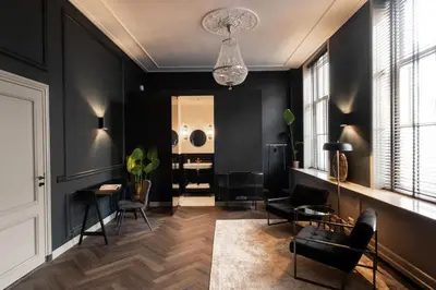 a living room with black walls and a chandelier at Steenhof Residence Warmond in Warmond