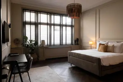 a bedroom with a bed and a large window at Steenhof Residence Warmond in Warmond