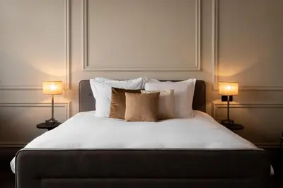 a bedroom with a bed with pillows and two lamps at Steenhof Residence Warmond in Warmond