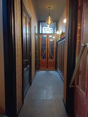 a hallway with wooden doors and a tile floor at Herberg De Hollandsche Leeuw in Nieuwkoop