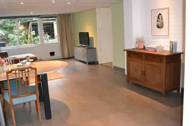 a living room with a table and a television at Nature and tranquility in Soest with Forest, Dunes and City in Soest