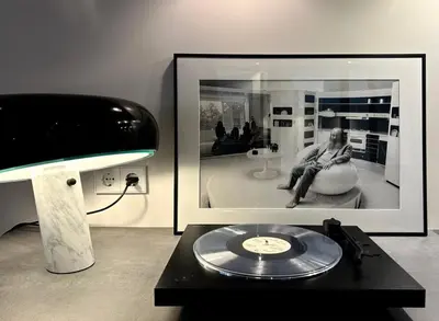 a table with a cd and a lamp and a picture at The Design apartment with canal-view in Amsterdam