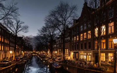 a canal in a city at night with buildings at The Design apartment with canal-view in Amsterdam