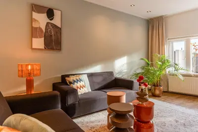 a living room with a couch and a table at Appartement de Burgemeester - centrum in Castricum