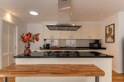 a kitchen with a vase of flowers on a counter at Appartement de Burgemeester - centrum in Castricum