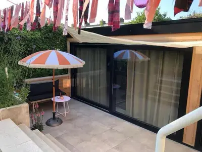 a patio with two umbrellas and a table at Logies at the sea in Katwijk aan Zee