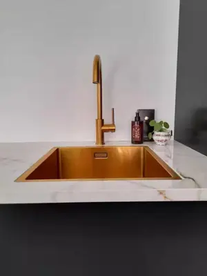 a kitchen sink with a brass faucet on a counter at Logies at the sea in Katwijk aan Zee