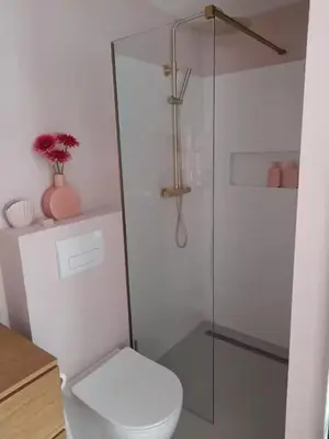 a bathroom with a toilet and a glass shower at Logies at the sea in Katwijk aan Zee