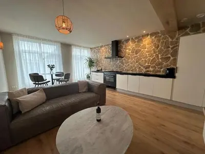 a living room with a couch and a table at Romantic jacuzzi suite in the city center in Bodegraven