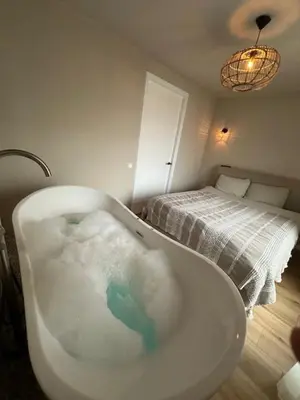 a bathroom with a bath tub filled with water at Romantic jacuzzi suite in the city center in Bodegraven