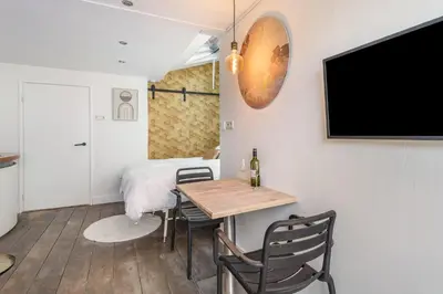 a room with a table and a bed and a tv at 2P studio in Utrecht city center in Utrecht