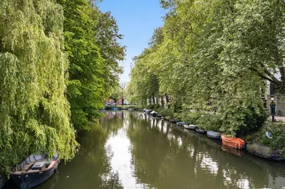 a river with boats on it with trees on the sides at 2P studio in Utrecht city center in Utrecht
