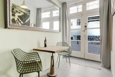 a dining room with a table and chairs and a window at Beautiful 'tiny-house' in Utrecht City Center in Utrecht