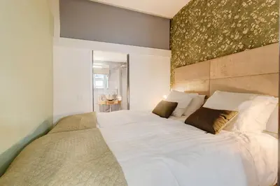 a bedroom with a large bed with white sheets at Beautiful 'tiny-house' in Utrecht City Center in Utrecht