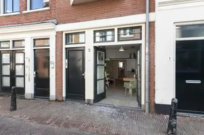 a brick building with black doors on a street at Beautiful 'tiny-house' in Utrecht City Center in Utrecht