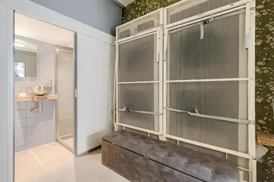 a bathroom with a shower with glass doors at Beautiful 'tiny-house' in Utrecht City Center in Utrecht