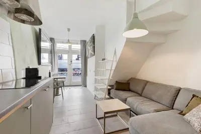 a living room with a couch and a kitchen at Beautiful 'tiny-house' in Utrecht City Center in Utrecht
