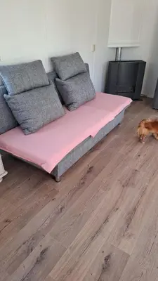 a large pink bed sitting on top of a wooden floor at Family Friendly Holiday Chalet with Pool in Holiday Park in Opmeer