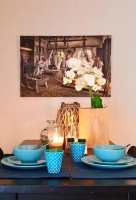a table with blue bowls and a picture on the wall at Blue City Apartment in Alkmaar