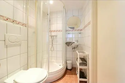 a white bathroom with a shower and a toilet at Blue City Apartment in Alkmaar