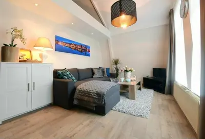 a living room with a couch and a table at Blue City Apartment in Alkmaar