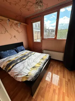 a bedroom with a bed in a room with windows at C-Home in Utrecht