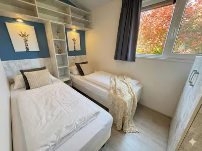 two beds in a small room with a window at Villa Sea Side am Markermeer Modernes Waterfront Haus 6 Pers in Bovenkarspel