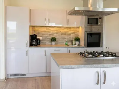 a kitchen with white cabinets and a stove at Villa Sea Side am Markermeer Modernes Waterfront Haus 6 Pers in Bovenkarspel