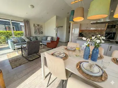 a kitchen and living room with a table and chairs at Villa Sea Side am Markermeer Modernes Waterfront Haus 6 Pers in Bovenkarspel