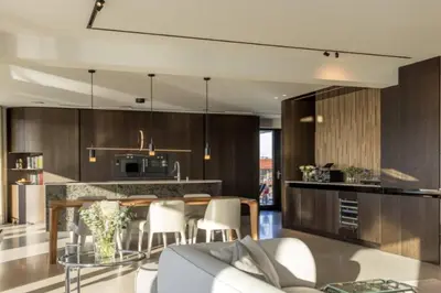 a kitchen with wooden cabinets and a table and chairs at Super View Penthouse Deluxe in Amsterdam