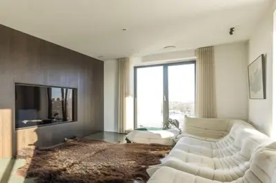 a living room with a white couch and a large window at Super View Penthouse Deluxe in Amsterdam