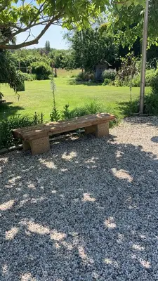 a wooden bench sitting in the middle of a park at Bij Parels landelijk overnachten in het groen in Velserbroek