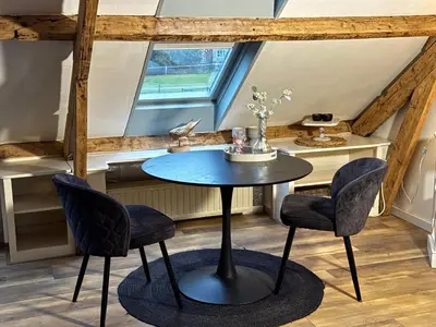 a table and chairs in a room with a window at Bij Parels landelijk overnachten in het groen in Velserbroek