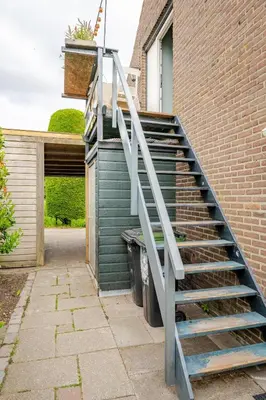 a staircase leading up to a building with a door at Bij Parels landelijk overnachten in het groen in Velserbroek