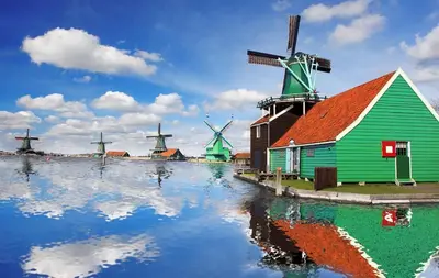 a group of windmills and a building with water at Private apartment with garden, close to Amsterdam in Assendelft