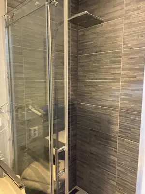 a shower with a glass door in a bathroom at Private apartment with garden, close to Amsterdam in Assendelft