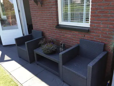 two wicker chairs and a table with a plant at Private apartment with garden, close to Amsterdam in Assendelft