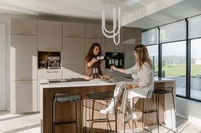 two women sitting at a kitchen island in a kitchen at 8 persons Wellness Villa Tulpenacker in Roelofarendsveen