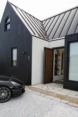 a black garage with a car parked in front of it at 8 persons Wellness Villa Tulpenacker in Roelofarendsveen