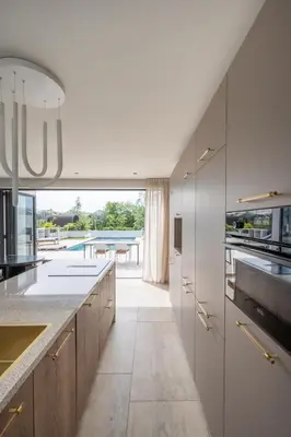 a kitchen with white cabinets and a view of a pool at 8 persons Wellness Villa Tulpenacker in Roelofarendsveen